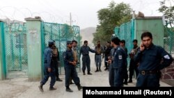 Afghan policemen stand guard near the site of blasts in the capital Kabul on June 3.