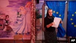 O femeie iese din secția de vot după scrutinul pentru alegerile locale și europarlamentare din 2024.