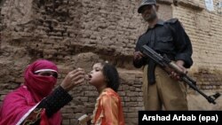 FILE: A polio worker administers polio vaccine to a child, in Peshawar, the provincial capital of Khyber-Pakhtunkhwa