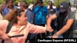 Младият мъж с маска, шапка и тъмна фланелка първо беше сред хората, провокирали сблъсъци с антиправителствени протестиращи, а след това няколко пъти отне със сила телефона на журналиста от Свободна Европа Полина Паунова и го изхвърли.