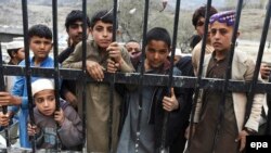 FILE: Stranded travllers wait to cross into Pakistan from Afghanistan at the Torkham border in March.