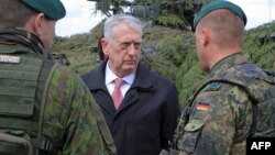 U.S. Defense Secretary James Mattis (center) talks with a German (right) and a Lithuanian soldier as he meets with U.S. troops deployed in Lithuania and other NATO troops on May 10.