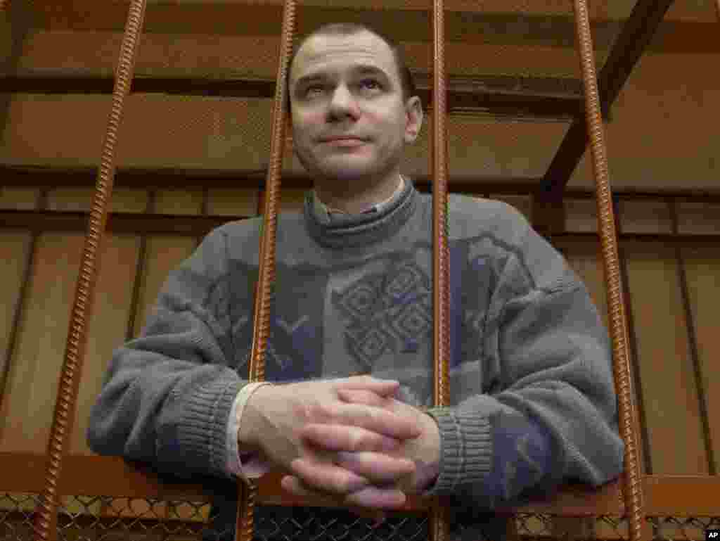 Руският ядрен учен Игор Сутягин зад решетките на 7 април 2004 г. в съдебна зала в Москва, докато съдът го обявява за виновен. Сутягин беше сред четиримата осъдени шпиони, които Медведев помилва, за да бъдат разменени за 10 руснаци, обвинени в шпионаж в САЩ.