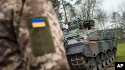 Imagine cu caracter ilustrativ, cu un soldat ucrainean în fața unui vehicul de luptă german, într-un centru de instruire din Germania, în 2023.