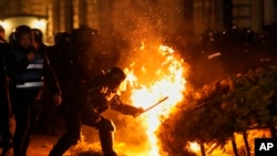 Полицијата се обидува да изгасне пожар за време на протестите на приврзаниците на Калин Георгеску во Букурешт, 9 март 2025 година