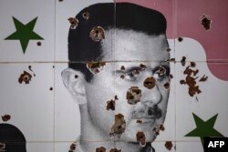 Portreti i presidentit të rrëzuar sirian, Bashar al-Assad, i dëmtuar nga vrimat e plumbave, në një mural në periferi të Damaskut.