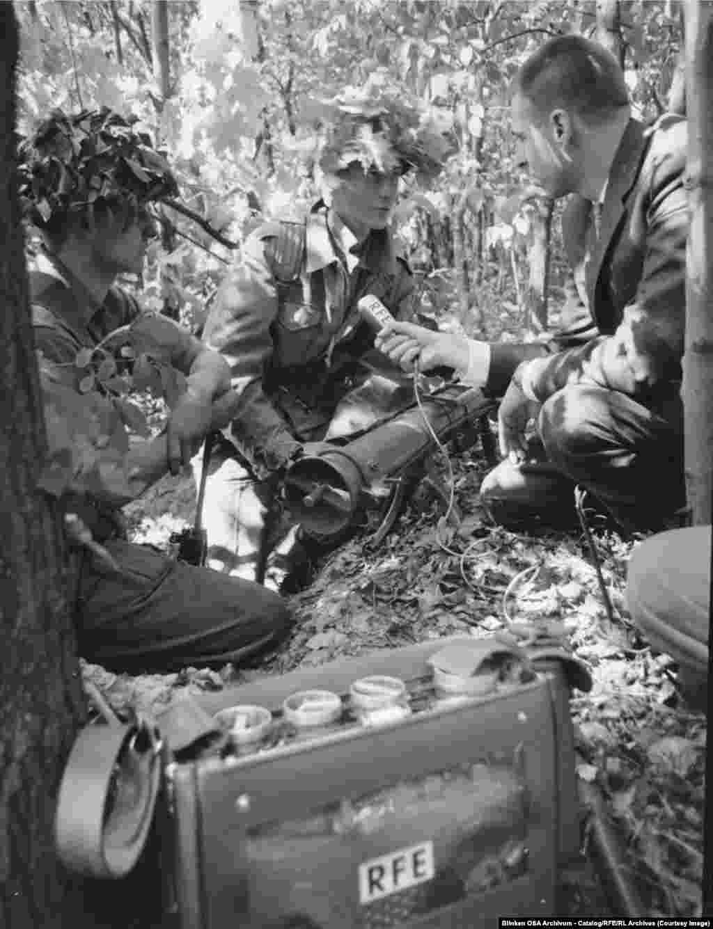 Озод Европа радиосининг Берлиндаги мухбири Том Бодин 1964 йилда Ғарбий Берлиннинг Груневальд ўрмонида ўтказилган Британия-Америка қўшма ҳарбий машғулотлари пайтида АҚШ аскари билан суҳбатлашмоқда.Радио репрессив режимлар остида яшаётган аҳолига етиб бориш учун идеал восита сифатида қаралган. Бунинг сабаби — эшиттиришни тинглаш из қолдирмас эди. Тингловчи радио тўлқинини эшитгач, шунчаки бошқа частотага ўтиши мумкин эди — бу унинг кимлигини фош қилмасди.