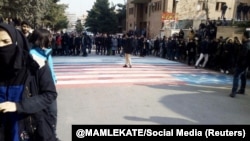 Students walk around, instead of across, U.S. and Israeli flags at the Shahid Beheshti University in Tehran on January 12. 