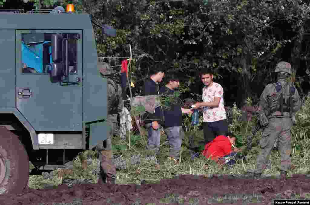 Bevándorlók csoportja katonák őrizetében a lengyel–belarusz határon szeptember 1-jén
