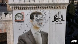 Un portret al lui Bashar al-Assad distrus de gloanțe în orașul Hama, la 6 decembrie.