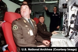 Doi ofițeri superiori din Forțele de Rachete Strategice Ruse stau pe scaunele unui simulator american de rachete nucleare folosit pentru antrenament.