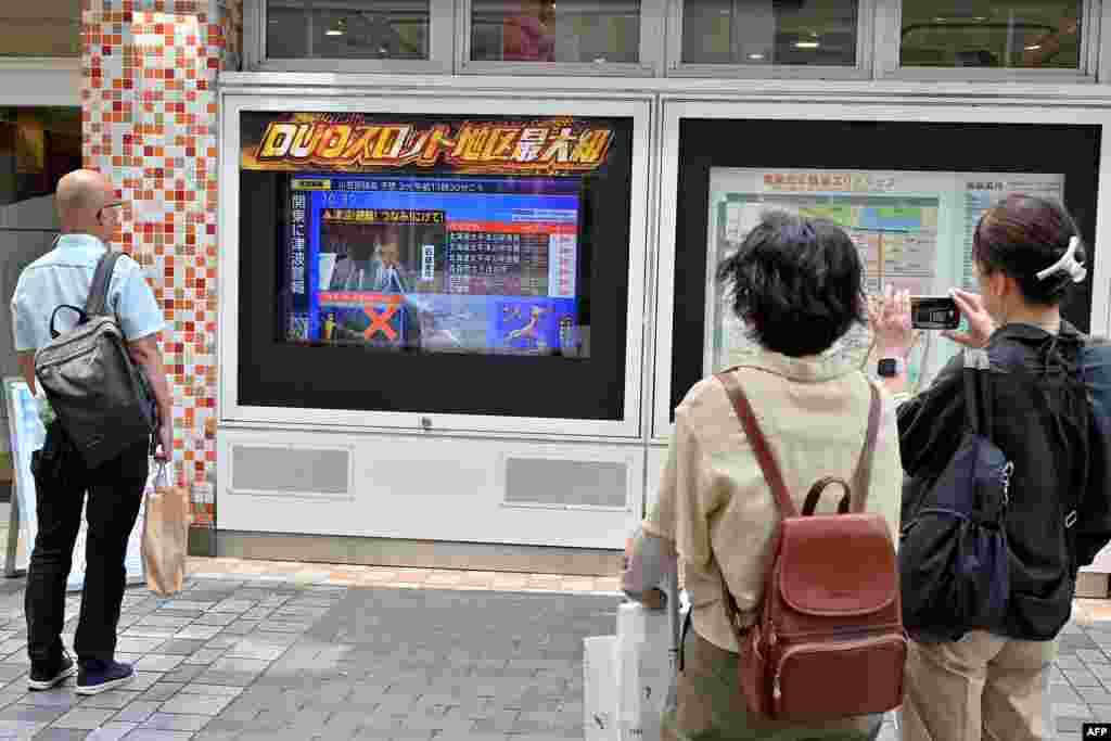 Kalimtarë në Tokio ndjekin lajmet pas paralajmërimit për cunam, në Japoni, më 30 korrik 2025.
