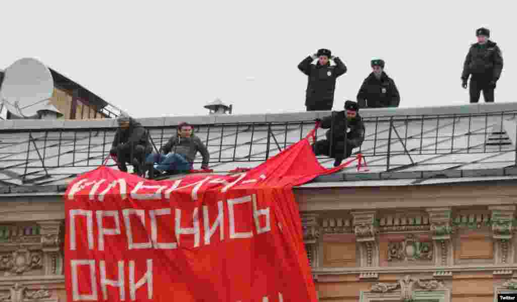 Poliția încearcă să-i scoată de pe un acoperiș, la Sankt Petersburg, pe activiștii mișcării de opoziție &bdquo;O altă Rusie&rdquo;, care au desfășurat o pancartă cu inscripția &bdquo;Ridică-te, Ilici, și vezi-ți fiii!&rdquo;, 4 noiembrie. Poliția a reținut, în total, 23 de oameni.