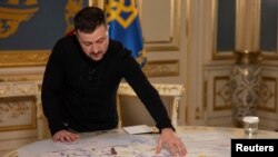 Președintele Ucrainei, Volodimir Zelenski, le arată jurnaliștilor agenției Reuters o hartă cu depozitele de minereuri rare pe care vrea să le împartă cu Statele Unite. 