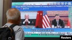 Kineski predsjednik Xi Jinpinga i američki predsjednik Joea Biden na ekranu u Hong Kongu, tokom emitovanja vijesti o njihovom razgovoru u septembru ove godine