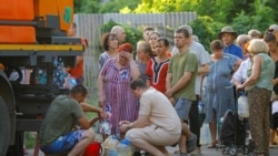 Residents wait in line to collect water delivered by a tank truck in the course of Russia-Ukraine military conflict, in Donetsk, a Russian-controlled city of Ukraine.
