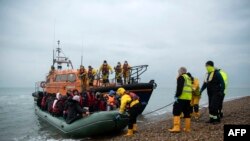 Migranți salvați din apele Canalului Mânecii de autoritățile britanice, sunt aduși la Dungeness, în sud-estul Angliei, 24 noiembrie 2021. În acest an, peste 25 de mii de persoane au sosit până acum ilegal în Marea Britanie, trecând Canalul Mânecii, din Franța.