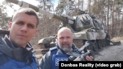 Дописникот на украинскиот сервис на РСЕ, Роман Пахулич и снимателот Павло Холодов, фотографирани во регионот Суми, Украина во 2022