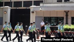 Un grup de polițiști chinezi trec pe lângă fostul sediu al Consulatului amercian din orașul chinez Chengdu, 27 iulie, 2020
