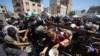 Palestinezët duke marrë ushqime në një qendrë të shpërndarjes në kampin e refugjatëve Nuseirat në pjesën qendrore të Rripit të Gazës. 19 korrik 2025. 
