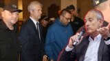 Спас Спасов (вдясно) на фона на служители на реда, които отвеждат кмета на Варна Благомир Коцев (в костюма) на съдебно заседание. Колаж.
