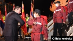Președintele Aleksandar Vucic (fără mască) îi salută pe experții chinezi care au adus ajutoare medicale la Belgrad, 21 martie 2020