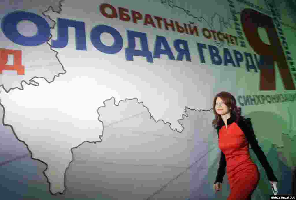 Месеци след шпионската сделка Анна Чапман потвърди публично лоялността си към Русия като се присъедини към младежкото крило на партията на Путин &quot;Единна Русия&quot;. На снимката тя върви по сцена в Москва, за да се присъедини към лидерите на прокремълското младежко движение &quot;Млада гвардия&quot;. 22 декември 2010 г.&nbsp;