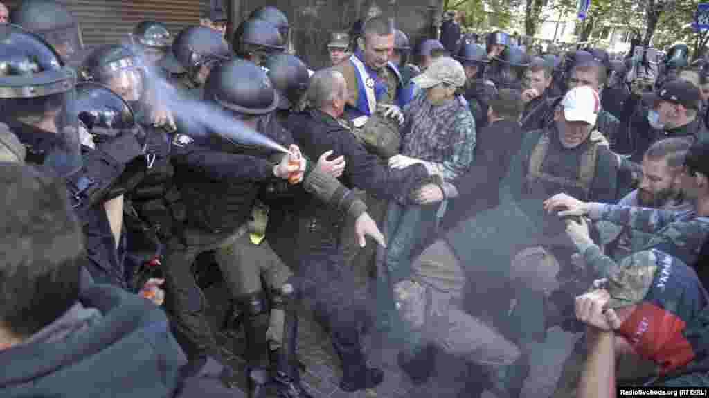 Силовик «поливає» себе зі сльозогінного балончика під час сутичок поліції та активістів під будівлею Генпрокуратури України. На акції протестували проти видачі ФСБ Росії етнічного інгуша Тимура Тумгоєва, який воював, за повідомленнями, на Донбасі проти російських гібридних сил. Київ, 17 вересня 2018 року ПЕРЕГЛЯНЬТЕ ФОТОГАЛЕРЕЮ