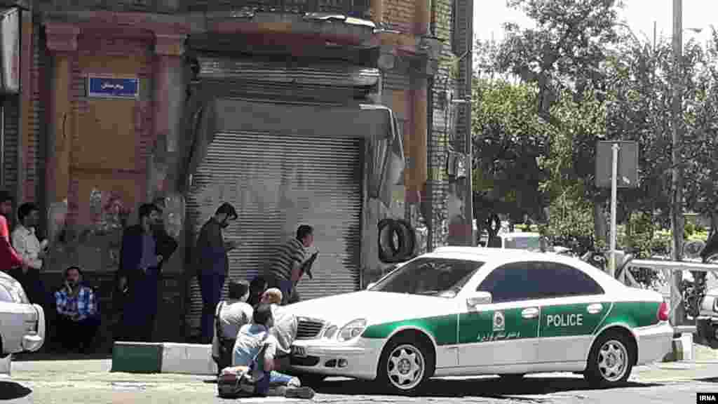 Journalists and armed police at the scene outside the Iranian parliament. 