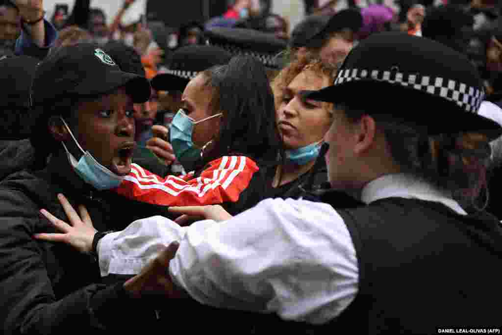 Manifestanți și ofițeri de poliție în fața ministerului de externe de la Londra, 3 iunie