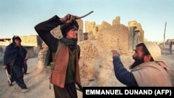 آرشیف، یک جنگجوی طالبان یک مرد را دره می‌زند. November 6, 1996