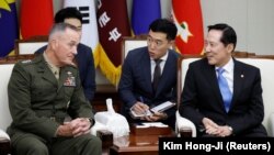 The chairman of the U.S. Joint Chiefs of Staff, General Joseph Dunford (left), talks with South Korean Defense Minister Song Young-moo (right) during their meeting at the Defense Ministry in Seoul on August 14.