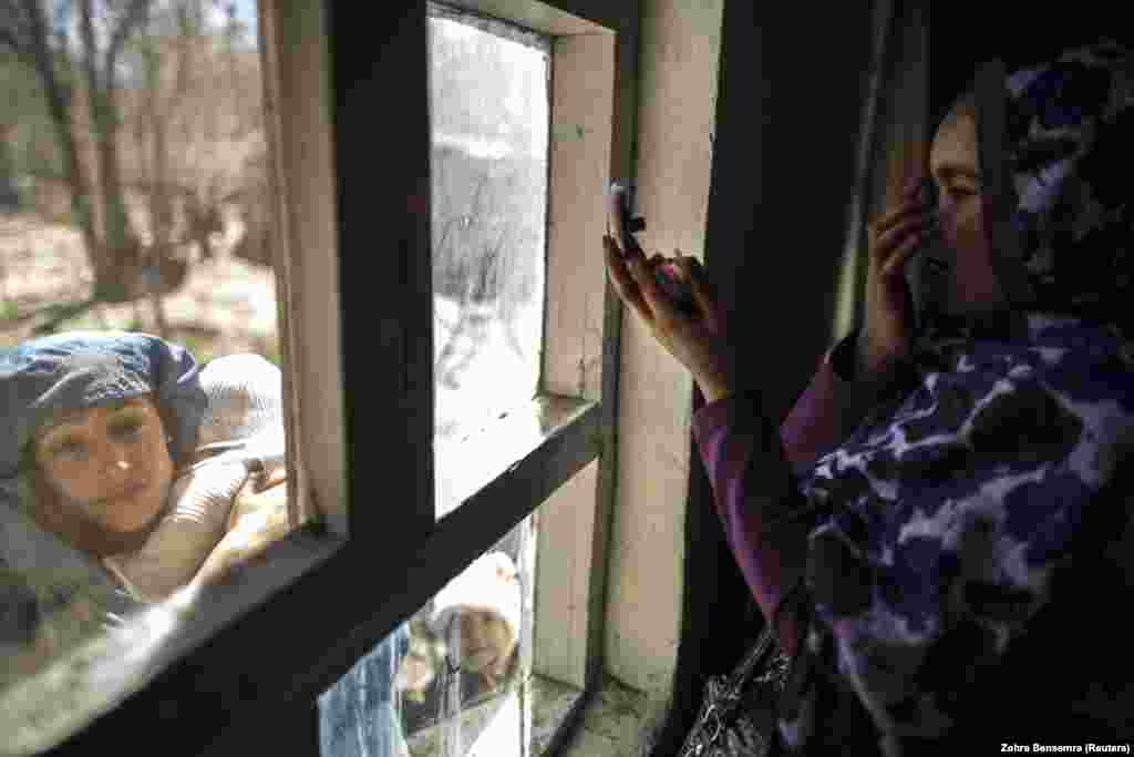 Žena se ogleda u ogledalu dok čeka da dobije svoj glasački listić u Centru za registraciju birača. (Kabul, 30. mart 2014)