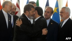 Iranian President Mahmud Ahmadinejad (right) embraces his Egyptian counterpart, Muhammad Morsi, as they attend the opening of a Nonalligned Movement summit in Tehran on August 30
